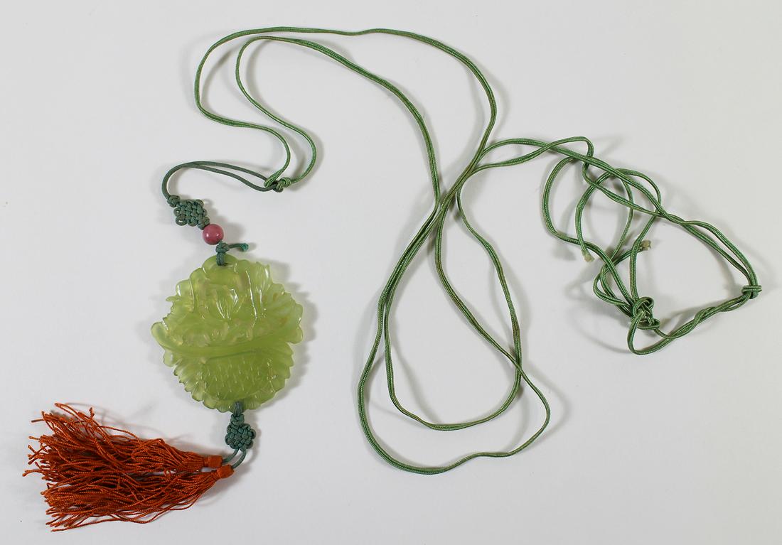 19TH CENTURY CARVED JADE PENDANT: A 19th Century carved pierced jade pendant. It is a light green color carved into a flower basket. It is strung on a silk string. The medallion measures 2 1/4" x 2 1/4". Purchased at Christie's Auctio