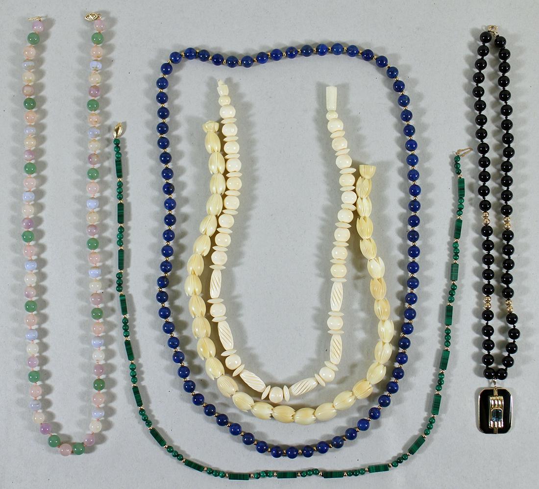 14K GEMSTONE NECKLACES: A collection of necklaces to include a 14K black onyx beaded necklace with a onyx and blue topaz, a 14K lapis lazuli necklace, a 14K malachite necklace, 14K multi colored stone necklace and 2 carved b