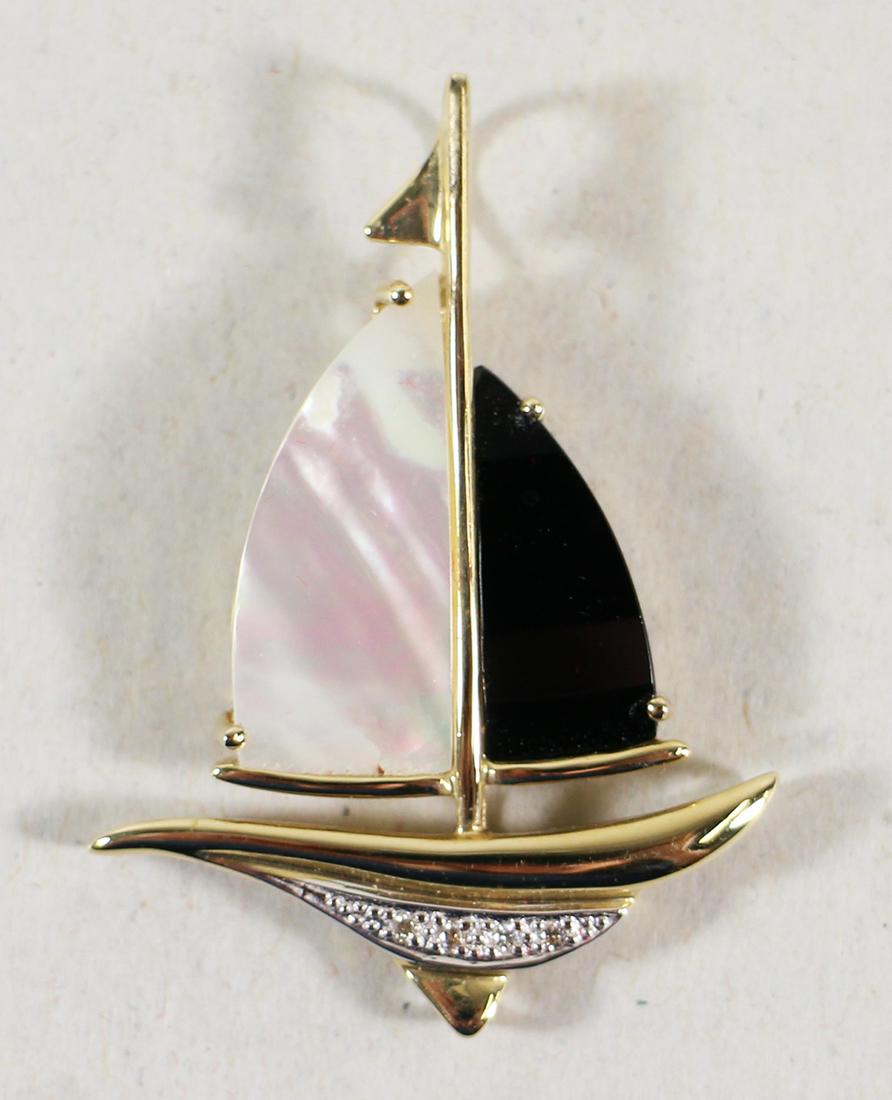 14K PEARL ONYX & DIAMOND SAILBOAT PENDANT: A 14KT yellow gold sailboat pendant with a mother of pearl and black onyx sail accented with diamonds. It measures 1 3/4" x 1 1/8". It weighs 6.5 grams.