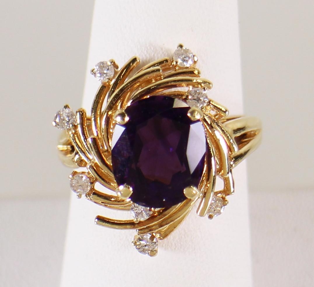 14K GOLD AMETHYST & DIAMOND RING: 14KT yellow gold ring with 3.00 carat oval amethyst accented by 8 round brilliant diamonds. It is set in 14KT yellow gold. Size 7 1/2. Weighs 7.8 g.