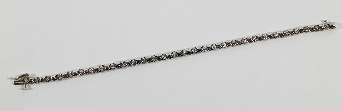 10K WHITE GOLD DIAMOND TENNIS BRACELET: A 10K white gold diamond XOXOXO bracelet. There are 30 round brilliant diamonds (.25 ctw) secured with a figure 8 safety clasp. It is 7 1/4" long and weighs 6.5 grams.