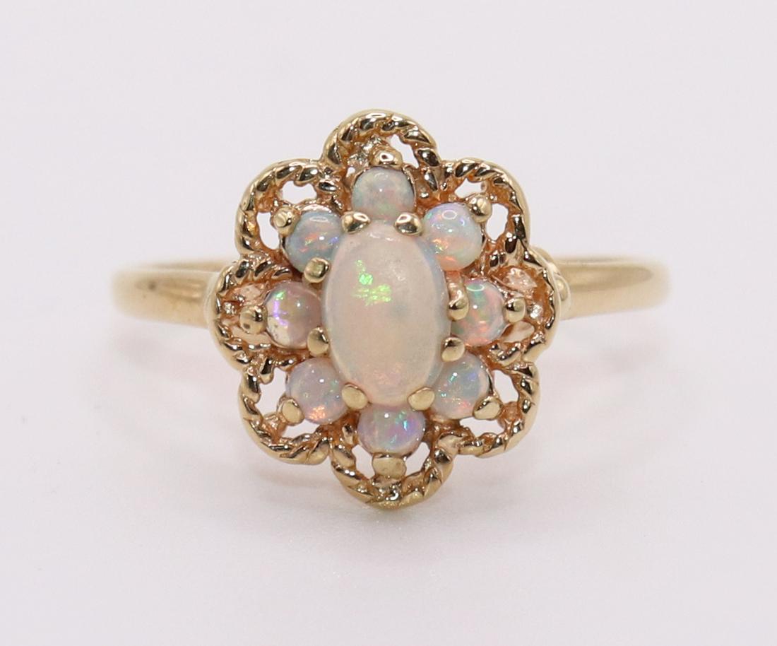 10KT AUSTRALIAN OPAL CLUSTER RING: 10KT Yellow gold ring with 6 x 3.5 MM oval opal and (8) 2MM opal surrounding accents. Filigree mounting. Size 7.25, weighs 2.2 grams.