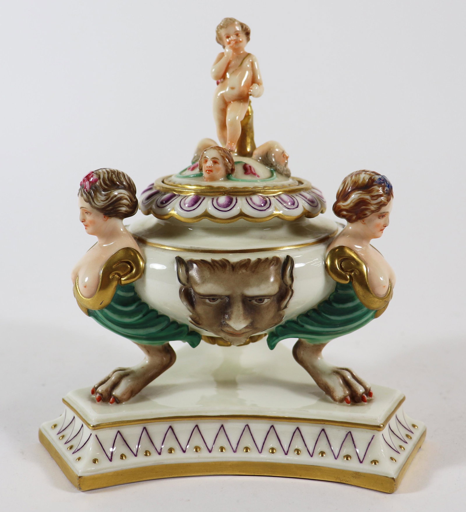 19TH CENTURY ROYAL WORCESTER ARIOSTO INKWELL: Porcelain inkwell with 3 semi nude caryatids on claw feet with applied satyr masks. Cupid on the top lid resting on a gold tree trunk along with 3 heads. Unmarked, attributed to Royal Worcester. Appro