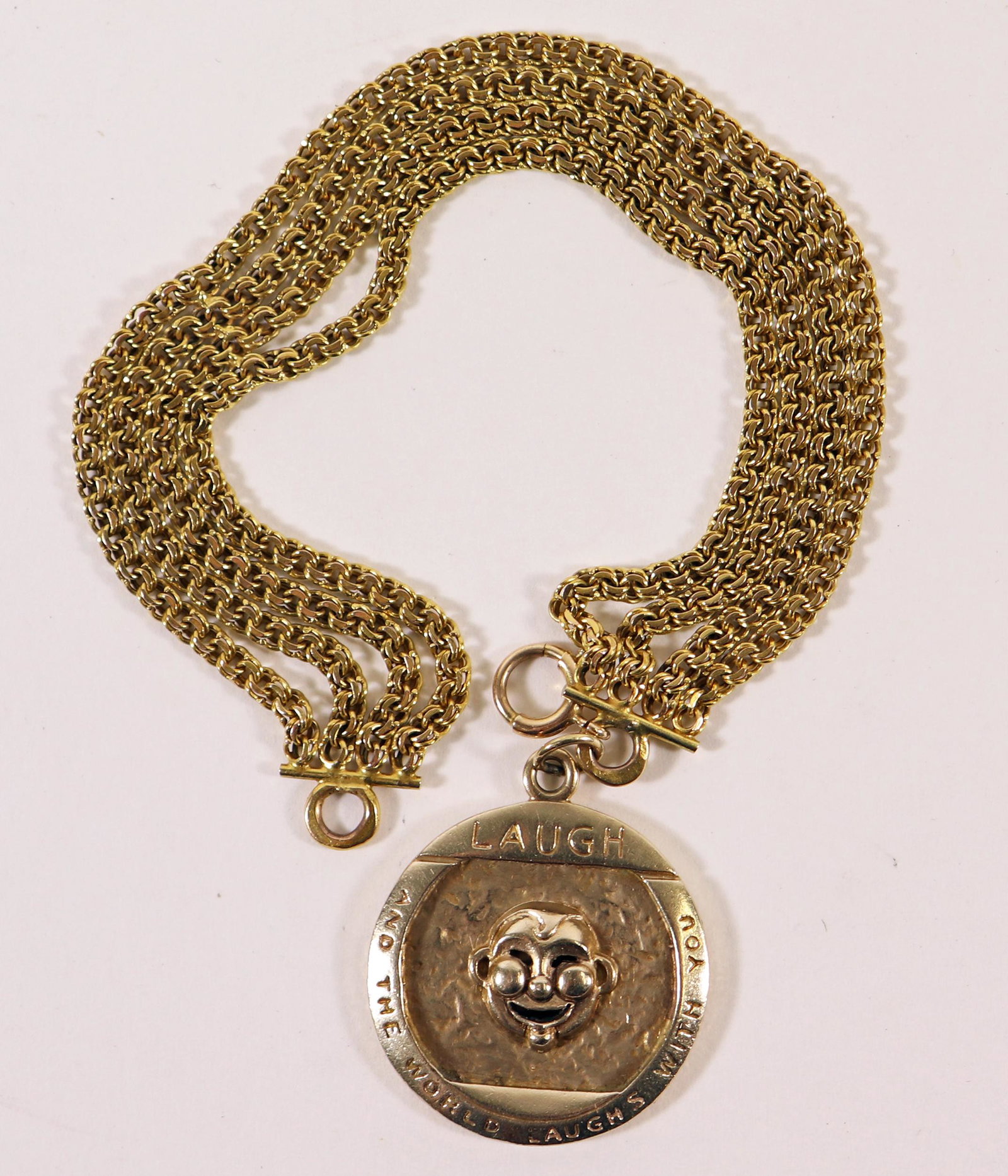 14K LAUGH AND THE WORLD LAUGHS WITH YOU BRACELET: 14KT yellow gold charm that reads, Laugh and the World Laughs with You. It is on a multi strand 14KT yellow gold bracelet. It weighs 15.5 DWT (24 grams), measures 6.5" long.