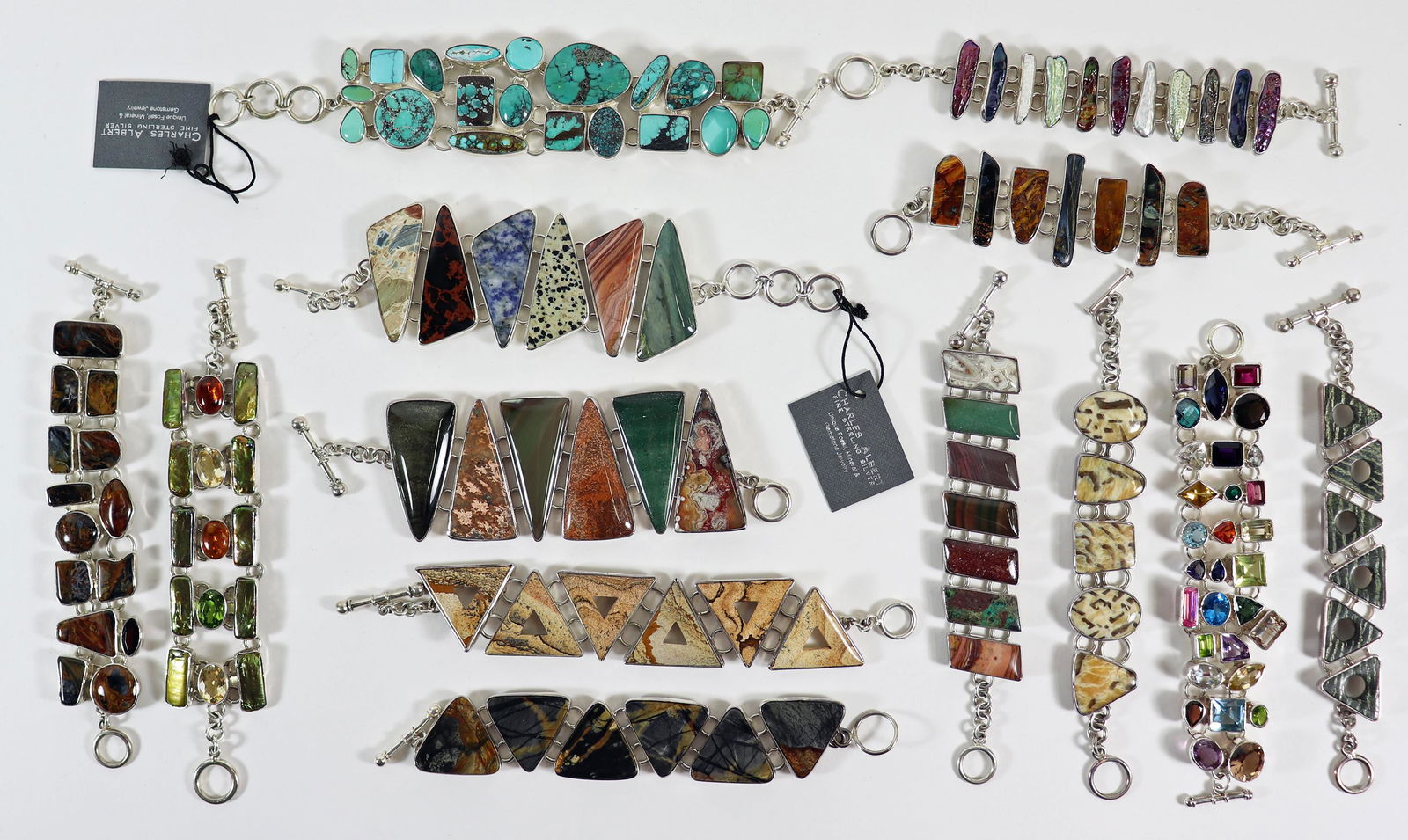 (13) CHARLES ALBERT STERLING SILVER BRACELETS: An assortment of Charles Albert sterling bracelets with assorted stones. Charles Albert jewelry is made of natural stones and can include Kyanite, Ammonite, Shark tooth, Geode, Pearl, Agate, Lapis, Ja