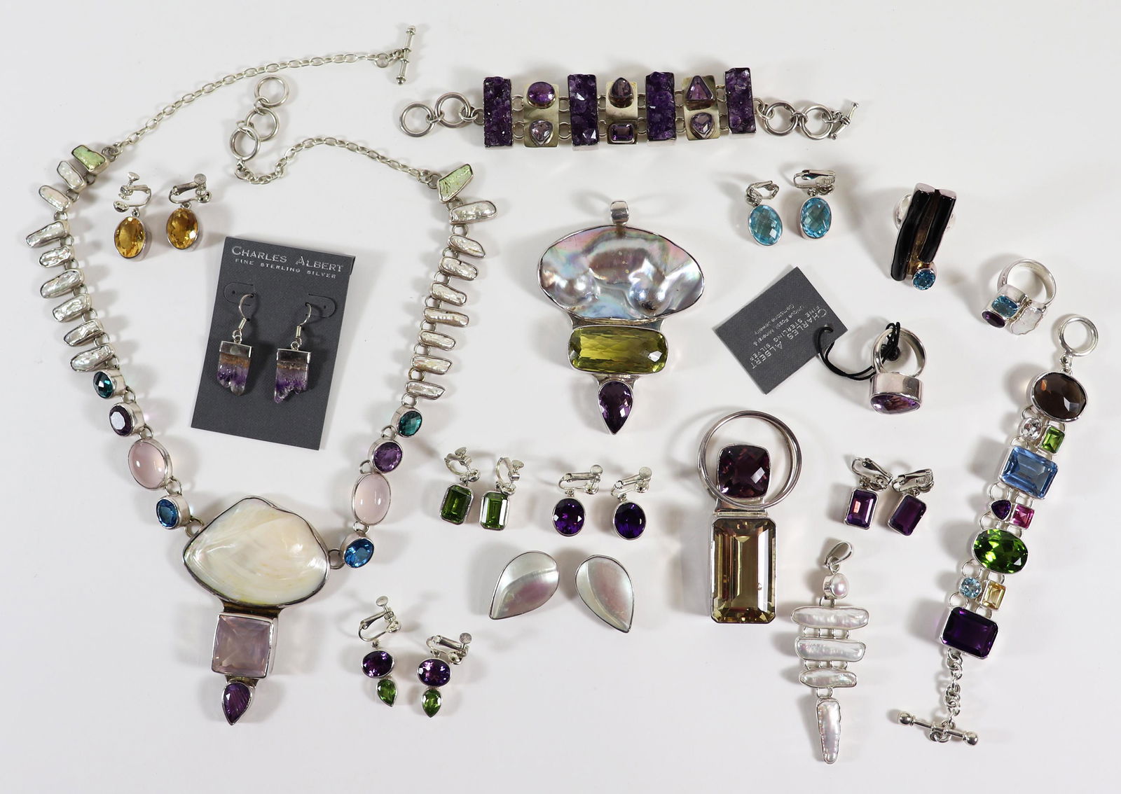 CHARLES ALBERT STERLING SILVER GEMSTONE JEWELRY: An assortment of sterling silver Charles Albert jewelry to include earrings, rings, pendants, bracelets, necklaces. Charles Albert jewelry is made of natural stones and can include Kyanite, Ammonite,