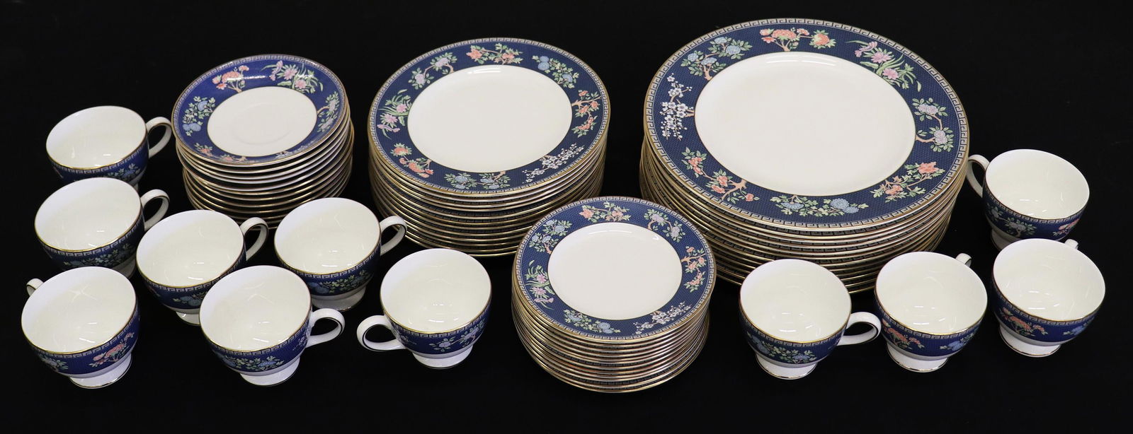 59 PIECE WEDGWOOD BLUE SIAM CHINA SET: Wedgwood Blue Siam pattern china set including (12) saucers and (11) cups, (12) 6" bread plates, (12) 8" salad plates, and (12) 10.75" dinner plates. According to the Wedgwood website, bone china is m