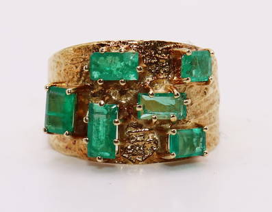 18K YELLOW GOLD COLOMBIAN EMERALD RING: 18KT yellow gold ring with 5 assorted sized Colombian emeralds. Textured finish on sides. Size 6 1/2. Weight 4.18 DWT