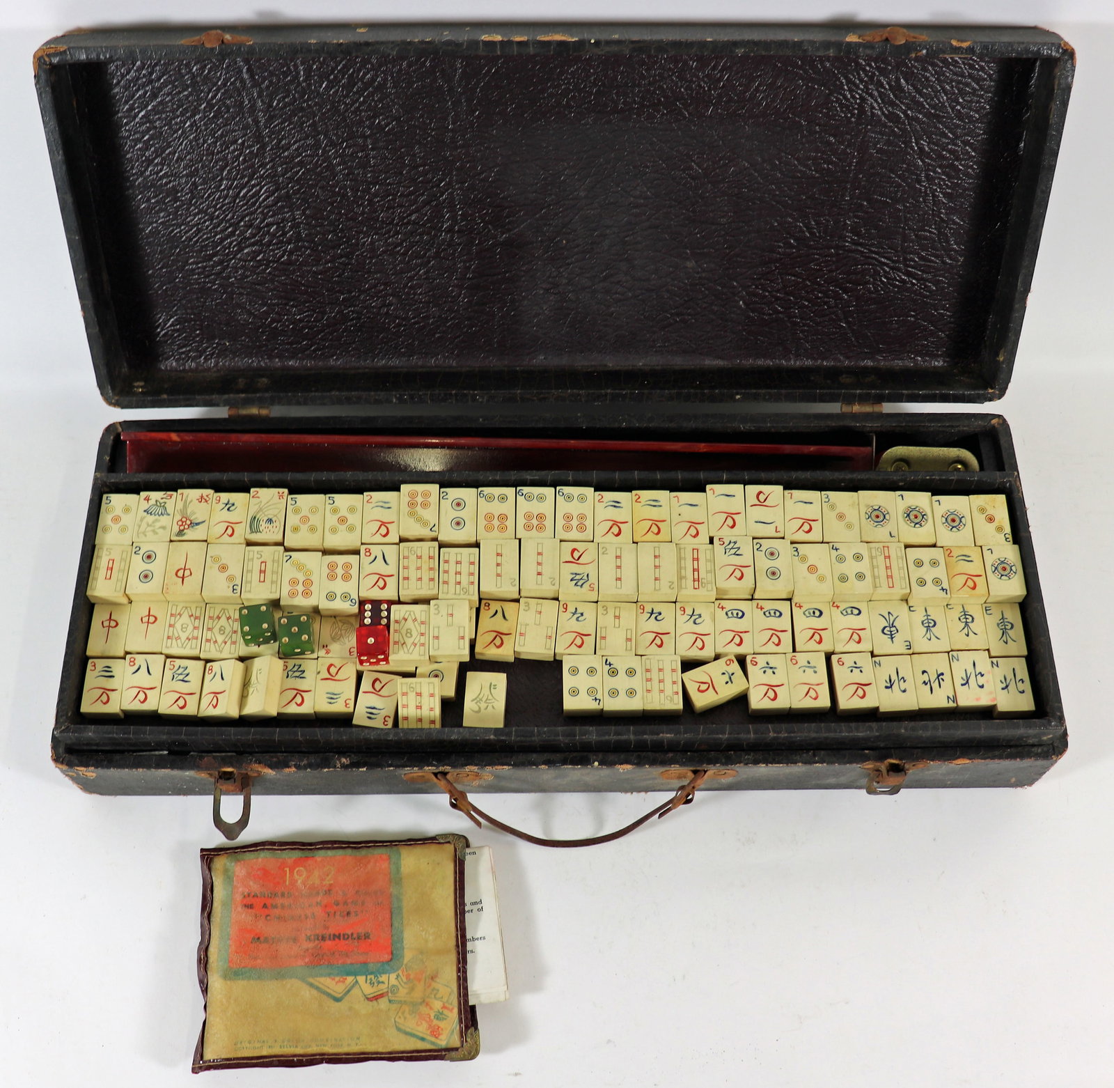 VINTAGE 1940's CHINESE MAHJONG SET: Older Mah Jong set with a total of 154 tiles that apprear to be solid bone. A 1942 rule book is included along with a very worn case.
