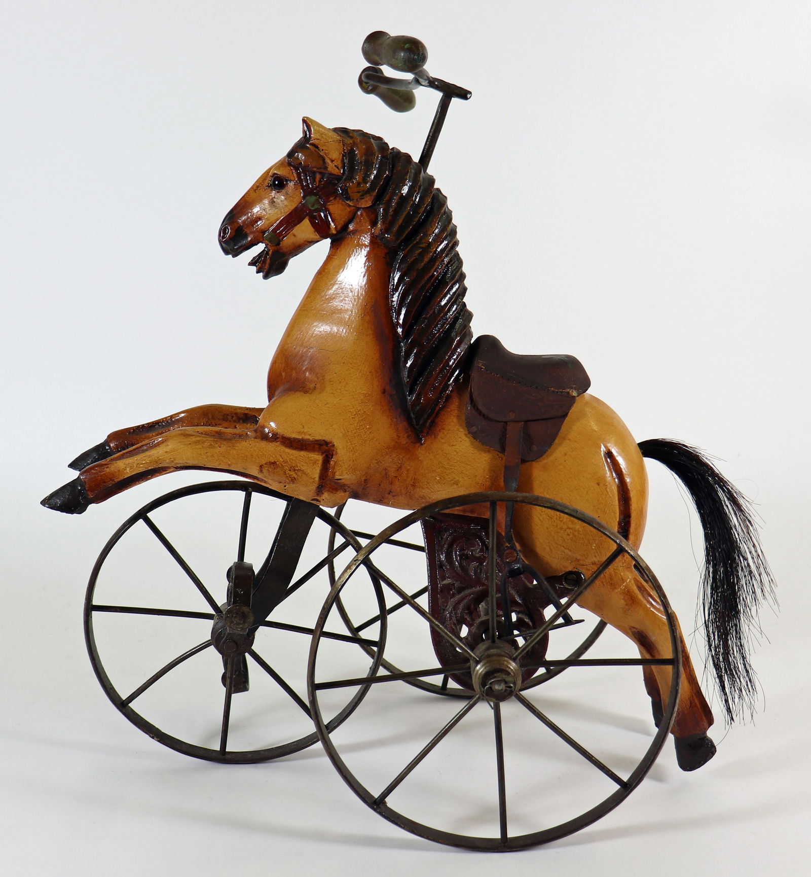 TOY HORSE TRICYCLE VELOCIPEDE: Toy wood horse tricycle with leather saddle. Measures 15" wide 17" tall.