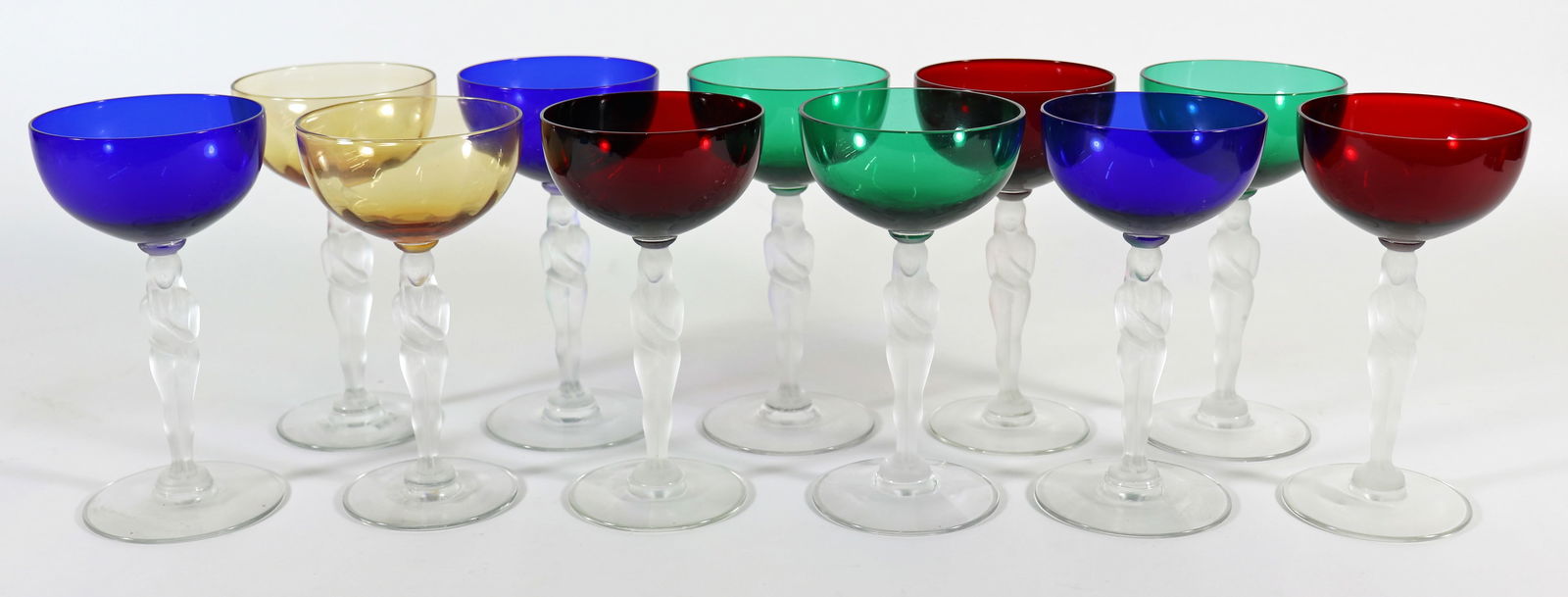 (11) NUDE STEM WINE COCKTAIL GLASSES: A set of (11) stem glasses with colored bowls in red, green, yellow, and blue. There is a frosted nude lady stem and a clear bottom. 6" tall.