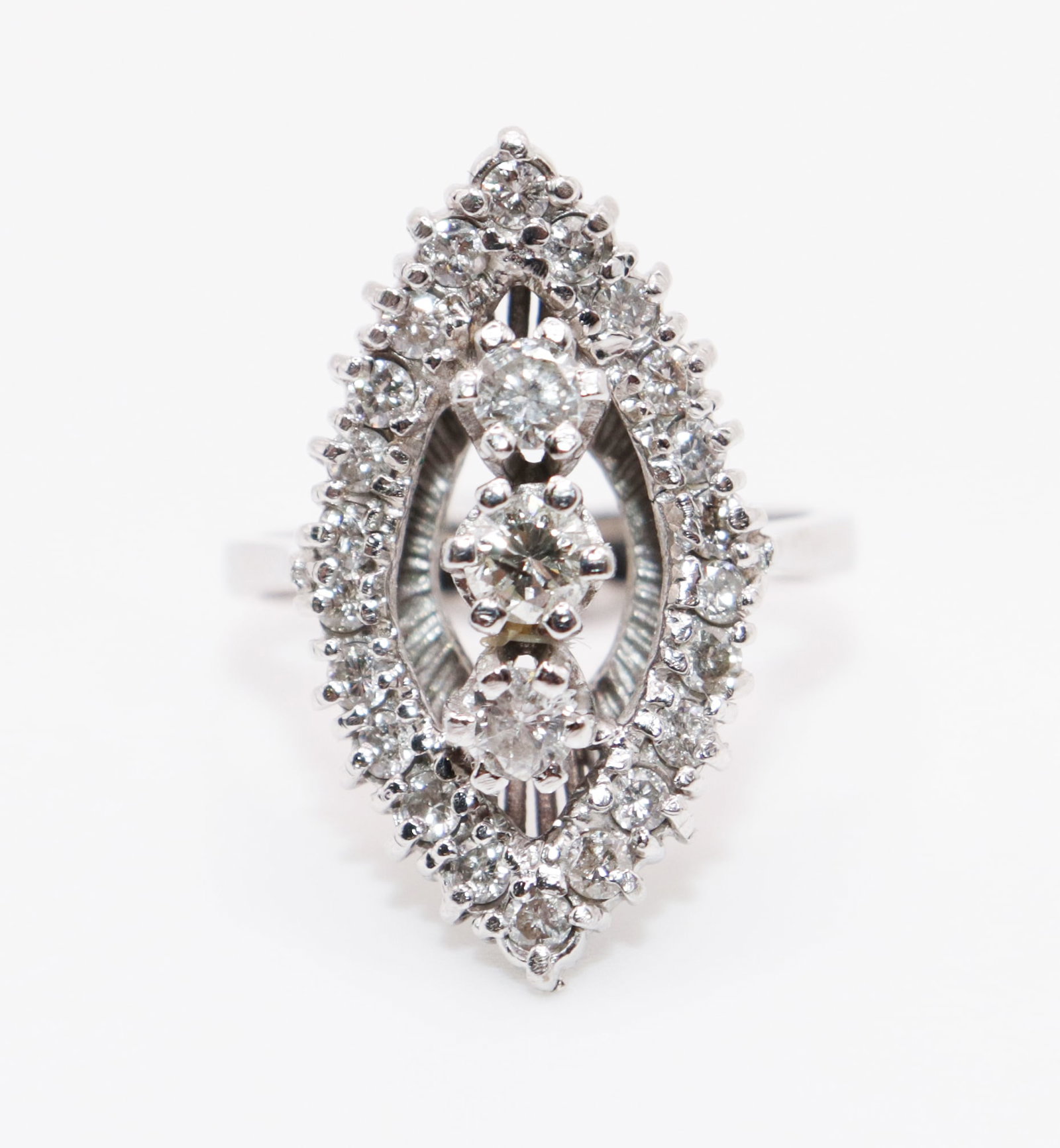 14K WHITE GOLD DIAMOND RING: A 14K white gold ring with a total of 25 sparkling white diamonds. There are 3 center approximately .15 carat diamonds surrounded by 21 .03 carat diamonds Size 6. The face of the ring is 1" long. Weig