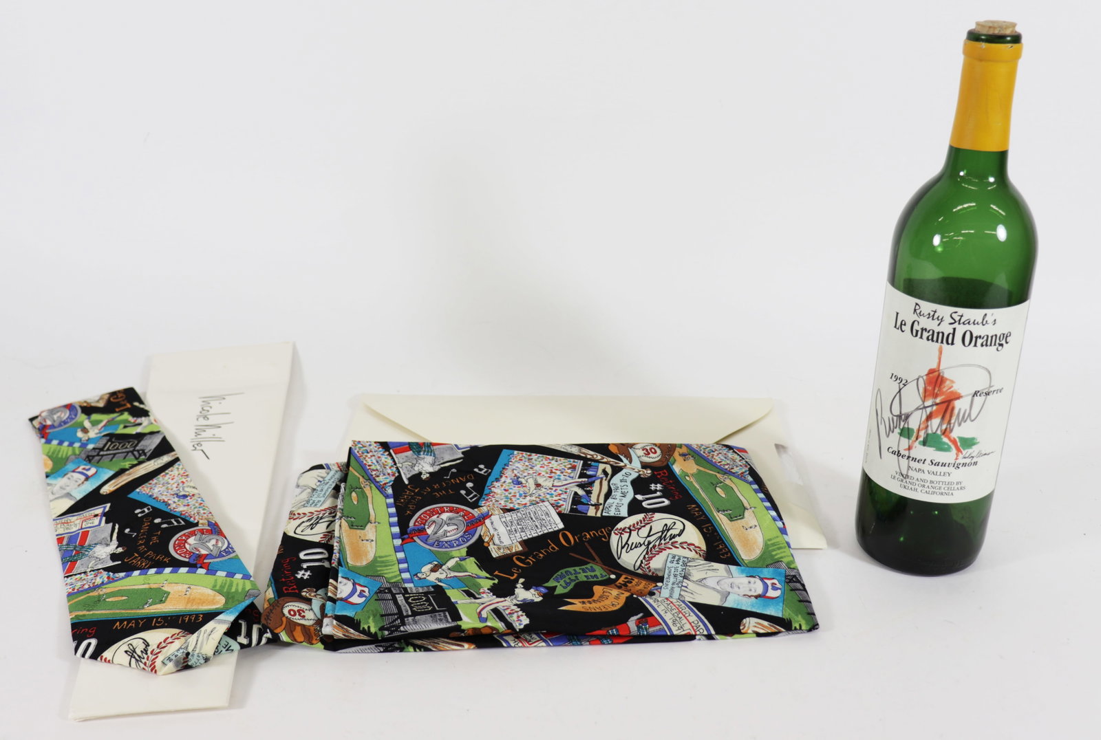 RUSTY STAUB SIGNED BOTTLE & ACCESSORIES: Rusty Staub autographed Le Grand Orange wine bottle with Leroy Neiman artwork and a new unused Nicole Miller scarf & tie.
