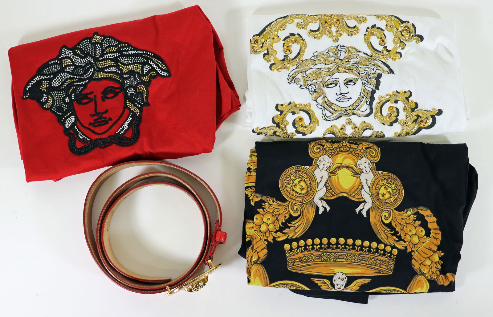 (4) GIANNA VERSACE MEDUSA LOGO TSHIRTS & BELT: Includes a 3 XL red t-shirt with rhinestone Versace Medusa logo on front, a 4 XL black v neck t-shirt with gold Versace design, and a 3 XL white t-shirt with Medusa sequined logo on front in gold and