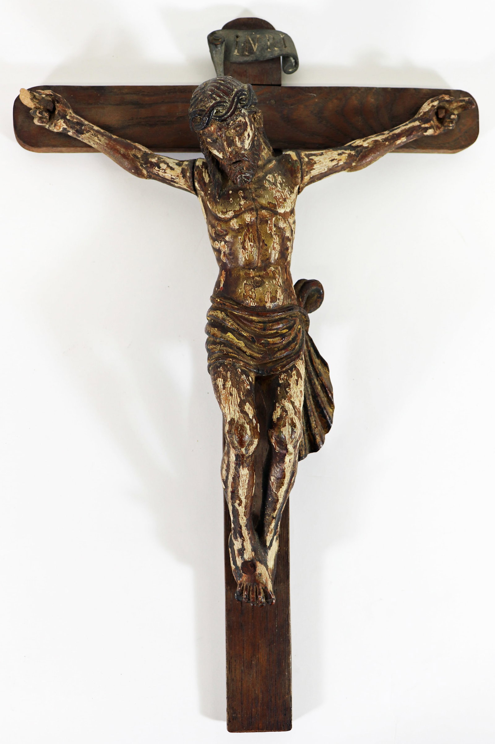 19th C. CONTINENTAL CARVED WOOD CRUCIFIX: A 19th century carved wood Santos of Jesus Christ hanging on the cross with INRI above his head. 17" x 11" x 3 1/2". Age related wear and loose nails. *From a Private Collector