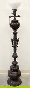 JAPANESE BRONZE FLOOR LAMP: Tall Japanese bronze floor lamp accented with dragons, cranes, trees, birds and more in a high relief design. Two handles on the sides. Measures 62" to base of shade. From the estate of Andrew Cunning