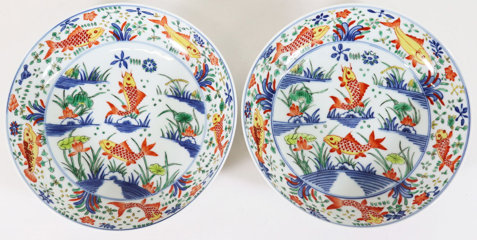 (2) CHINESE WUCAI PORCELAIN ROUND BOWLS: Pair of Chinese Wucai porcelain shallow bowls with fish design. Each with blue six character mark on bottom. Bowls measure 2" tall 7" wide. From the estate of Andrew Cunningham Ware.