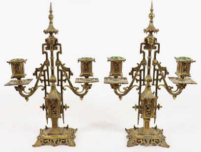 PAIR OF VINTAGE ORNATE BRASS CANDLELBRAS: A pair of vintage ornate brass candelabra candle holders with intricate design, French Gilt, in Gothic revival style. Each candelabra has two arms and each arm holds a candle cup. Measures 13 1/4" tal