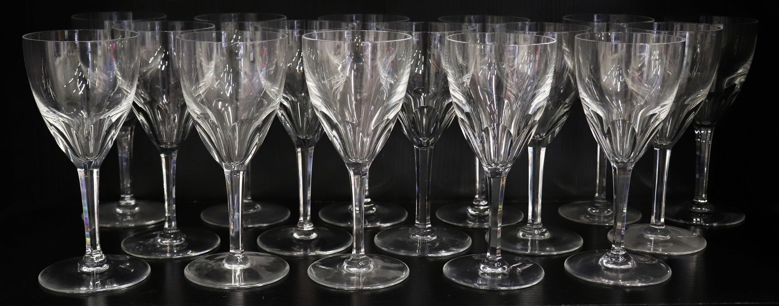(17) BACCARAT CRYSTAL GENOVA GLASSES GOBLETS: Collection includes 17 Baccarat crystal water / wine goblets in the Genova pattern with a thumbprint cut bowl. Stamped on underside. 20th Century, France. Measures 7 1/2" tall.