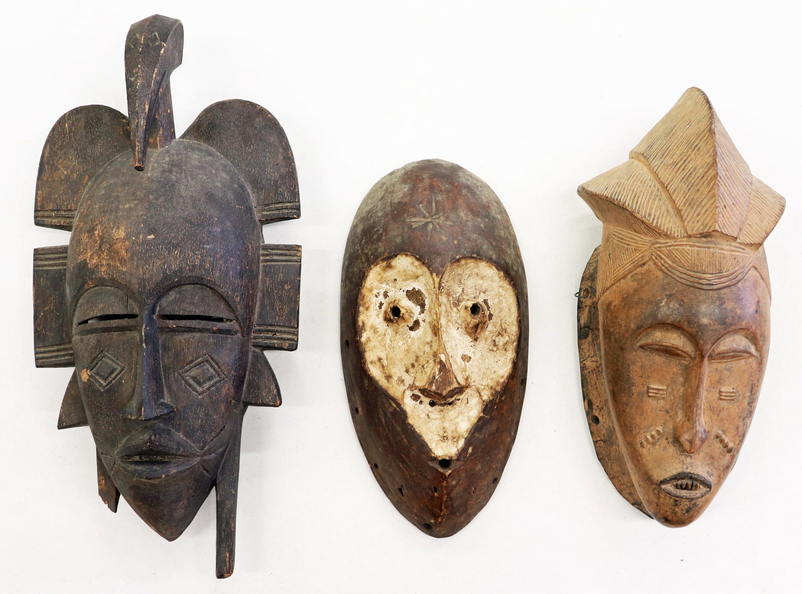 (3) PRIMITIVE AFRICAN TRIBAL WOOD MASKS: A collection of African tribal wood masks. One with loss to bottom / handle area. 11.25" to 16" long.