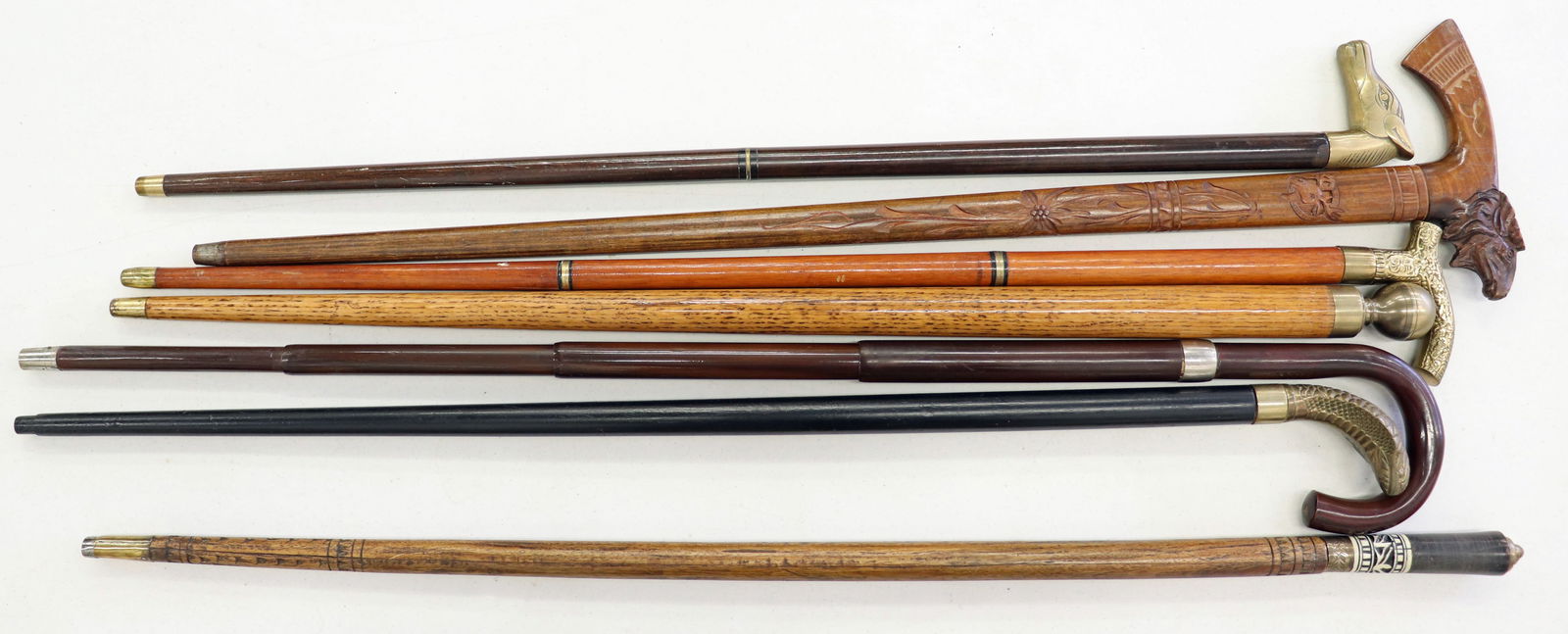 (7) VINTAGE NOVELTY GADGET WALKING STICK CANES: Includes a brass handled pool cue stick, a hidden umbrella cane, a brass cobra snake handle cane, a brass knob handle walking pointer stick with a hidden glass flask, an inlaid bone carved wood walkin