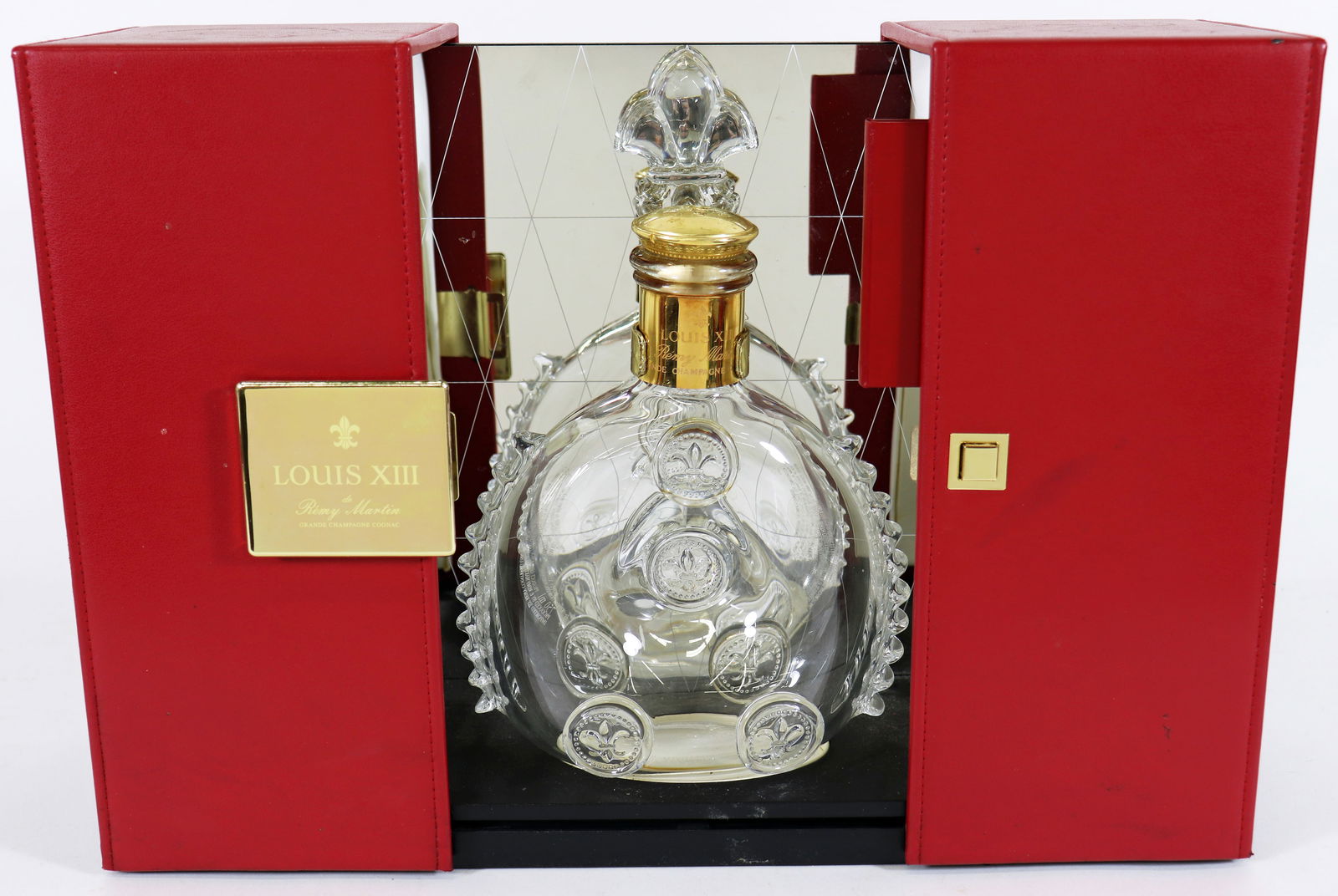 BACCARAT REMY MARTIN CRYSTAL DECANTER: Baccarat Louis XIII Remy Martin Crystal Decanter with original red display box with mirrored background, Measures 10 1/2 x 7" x 2 1/2" .Boxed measures 12" x 10" x 5 1/2". Light wear to box.