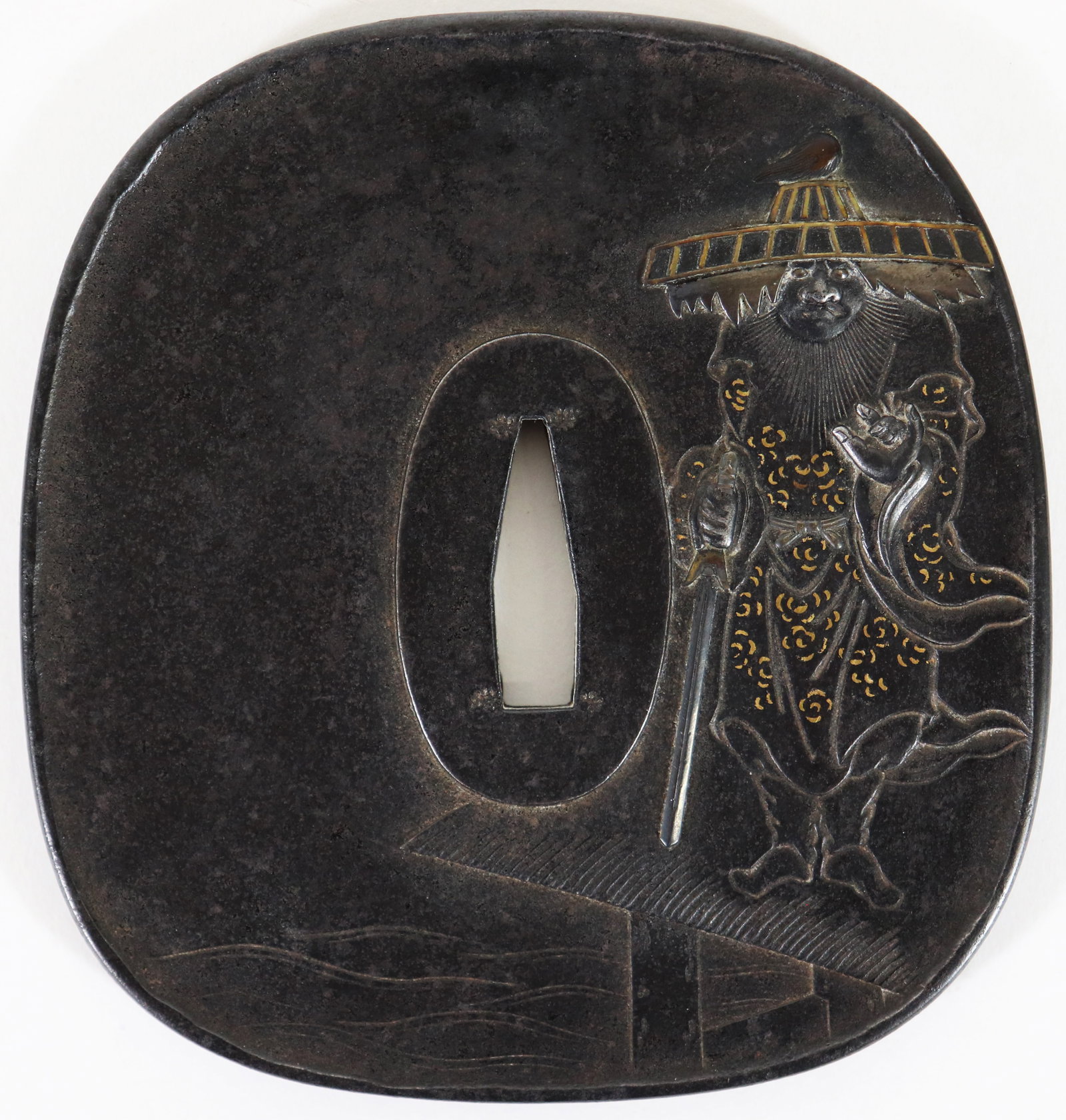 JAPANESE TSUBA W/ STANDING FIGURE: Japanese metal Tsuba sword guard. One side with standing figure holding a sword and gold accents. Verso with creature hugging a tree branch with a mixed metal design. Signed on verso. Measures 3.75" x