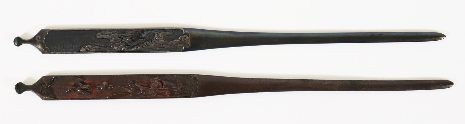 (2) JAPANESE METAL KOGAI: Two metal Japanese kogai grooming tools with high relief scenes on handle. One depicts a birds and the other with a figure in a boat. From the Estate of Japanese collector R.W. Lightner.