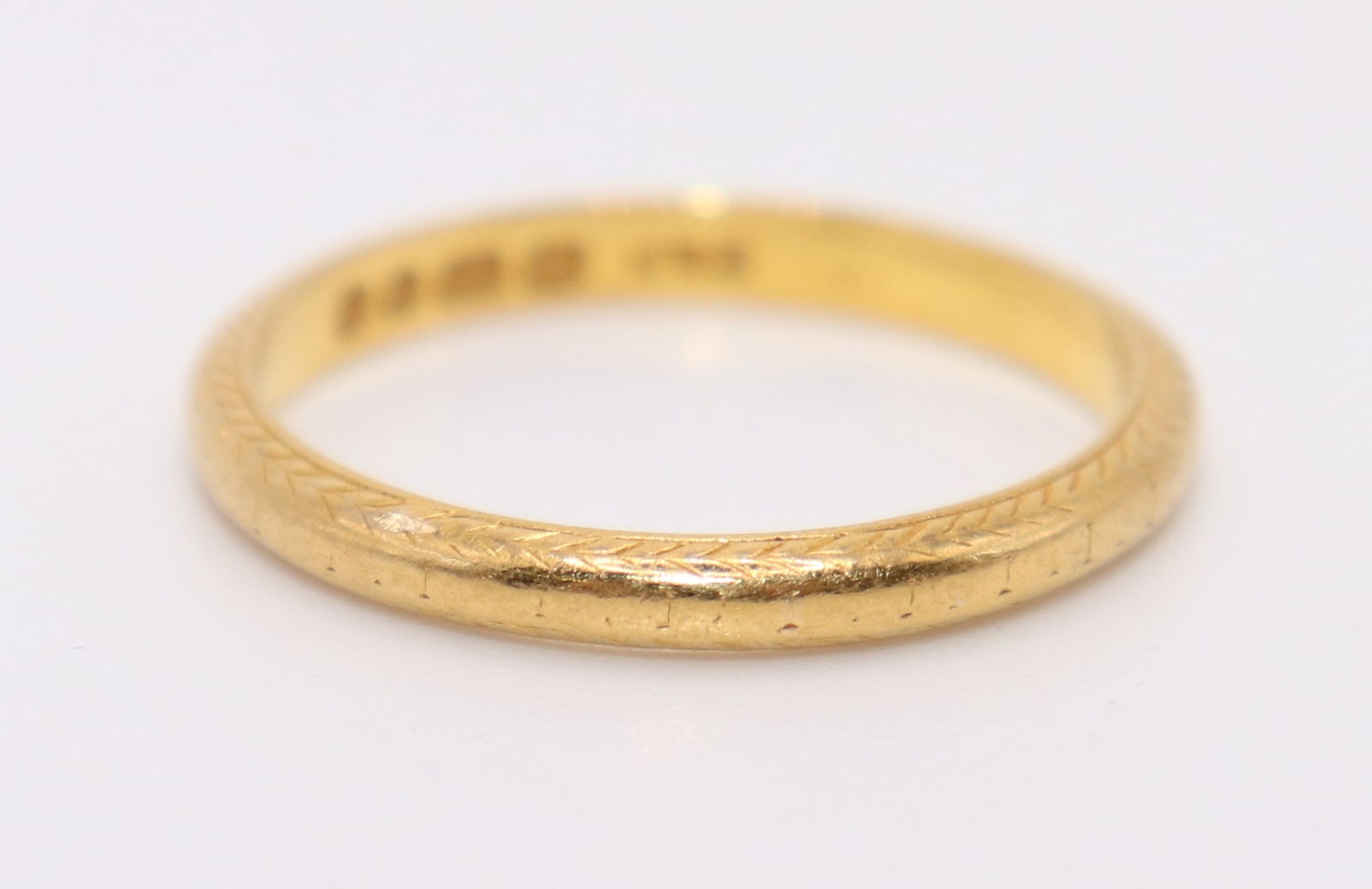 22K YELLOW GOLD WEDDING BAND: An English 22K yellow gold hallmarked wedding ring with etched design. Size 8 1/2 and weighs 3.3 g.