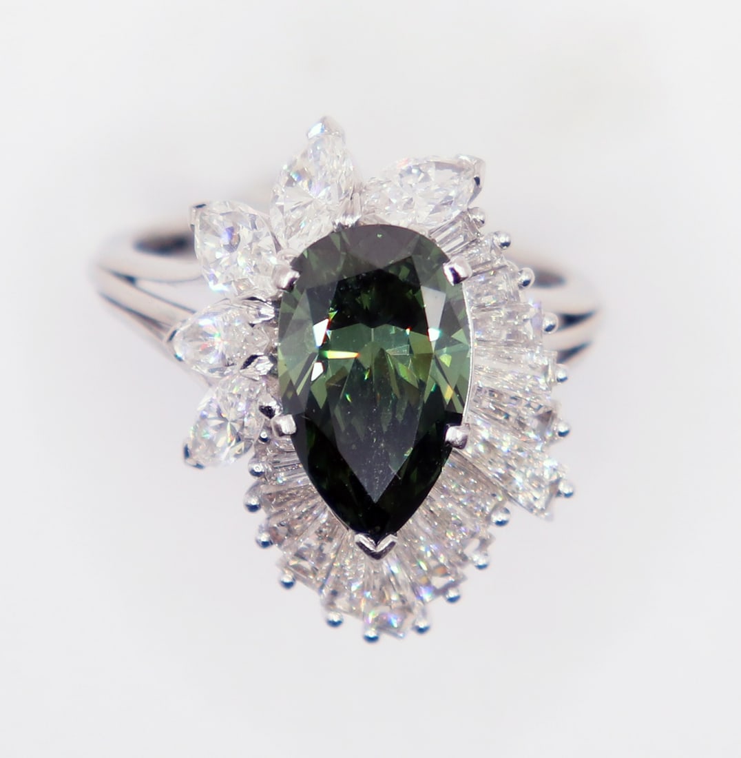 PLATINUM PEAR SHAPE 3.00 CT GREEN DIAMOND RING: A pear shaped green colored irradiated diamond approx 3 carats surrounded by approx 2 carats of sparkling diamonds. It is set in platinum. Size 8 1/2 and weighs 9 grams.