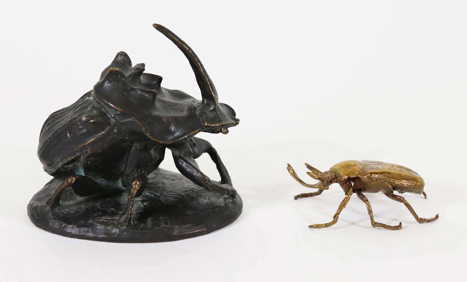 (2) GEORGE FOSTER BRONZE INSECT SCULPTURES: George Foster (Canada, b. 1939) Two bronze insect / beetle sculptures. Larger beetle signed George Foster 1988 and titled Phanaeus Lancifer. Measures 4" wide 3.75" tall. Smaller beetle with a gold