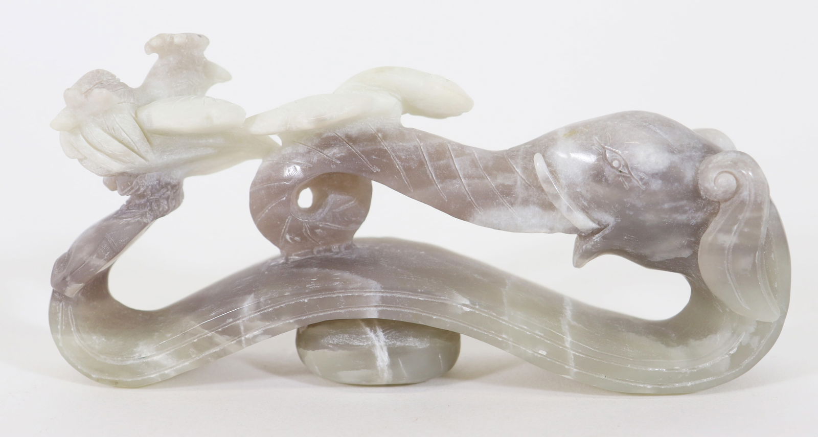 CHINESE CARVED JADE BELT BUCKLE: A carved Jade / Jadeite stone Ruyi scepter or belt hook buckle with an elephant and a bird resting on his trunk. Measures 6" L x 2.75" T x 1.25" W.