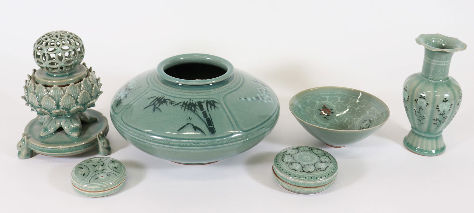 (7) KOREAN CELADON PORCELAIN COLLECTION: Korean Celadon Porcelain collection includes: two small covered trinket boxes with lids, measuring 2 3/4" round, and 3 1/4" round, each signed by artist, a flower vase with floral design with vertical