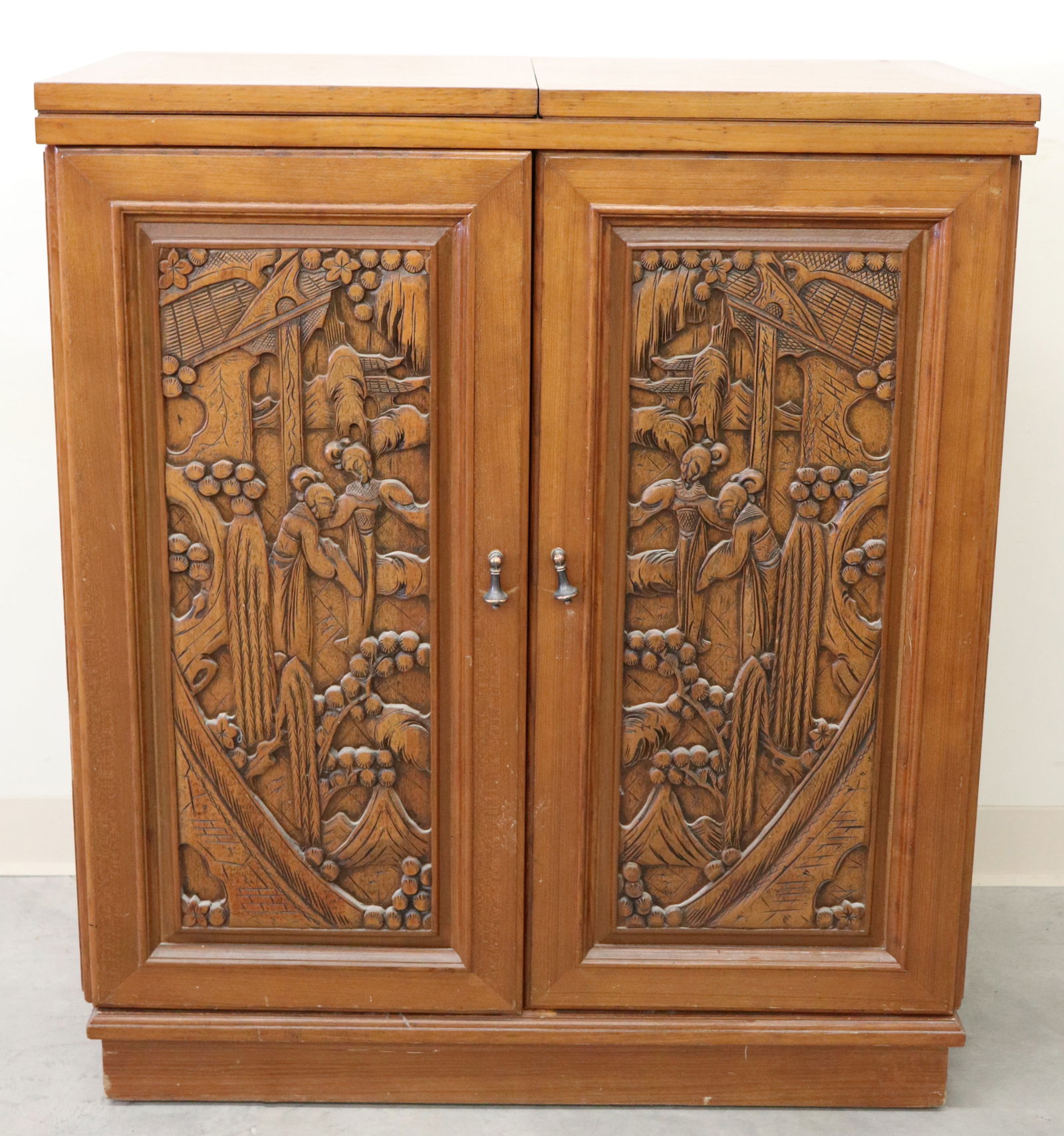 VINTAGE MID CENTURY ASIAN WOOD BAR: Vintage Asian wood bar cabinet with carved high relief figures. Top with two folding leaves. Measures 40 1/2" x 35 1/2" x 18"