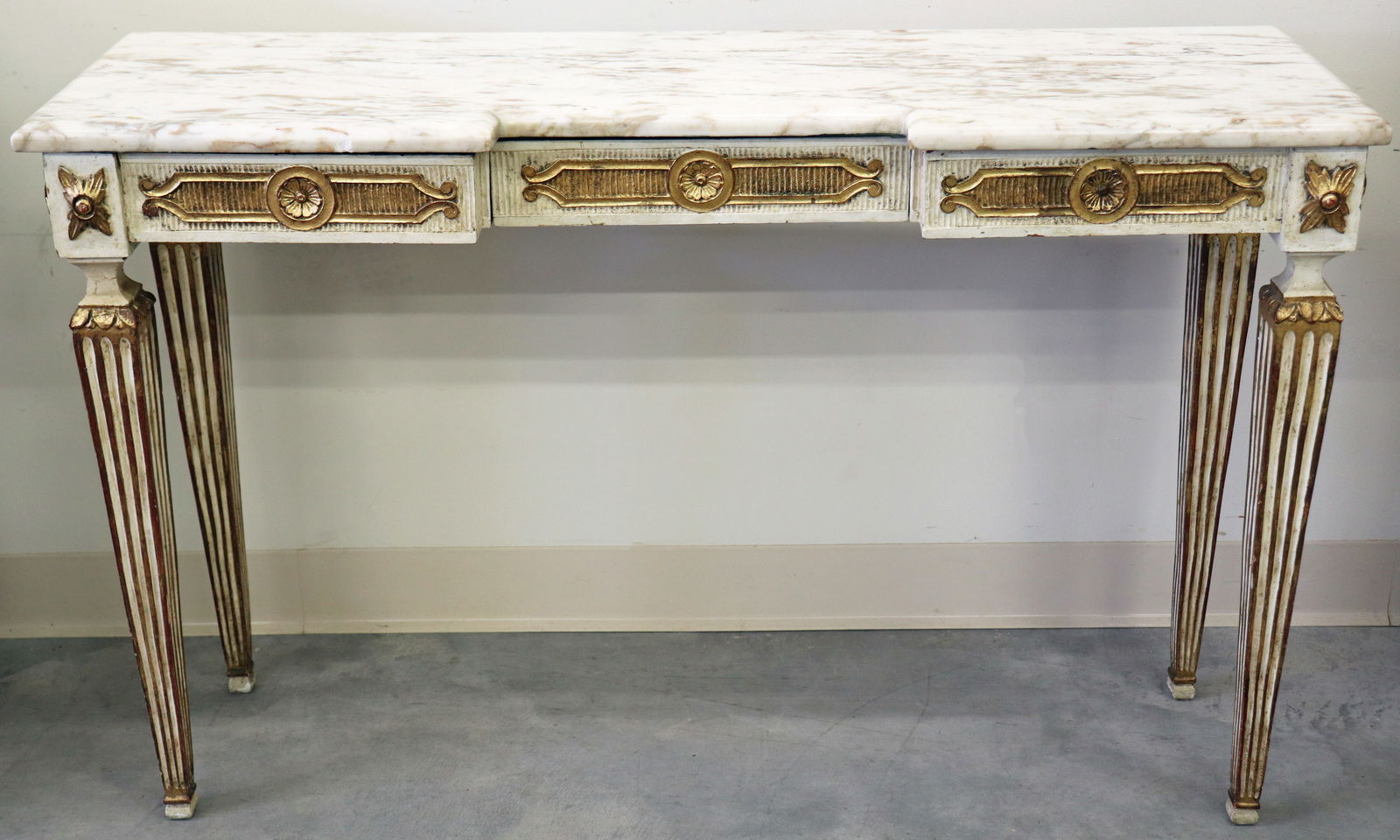 ITALIAN GOLD GILT AND MARBLE TOP CONSOLE TABLE: An antique Italian console table with one middle drawer, marble top in cream, gold, tan and browns, with four carved legs, carved gold gilt floral medallions around table. Measures 28" x 43 1/2" x 13"