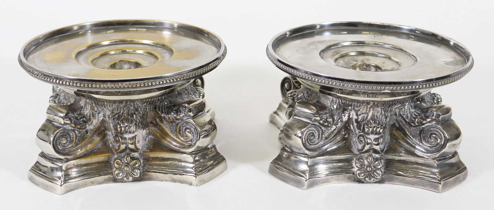(2) HEAVY SILVER PLATE CANDLESTICK HOLDERS: Pair of vintage candlestick holders in an ornate neoclassical style design with leaves and scroll motifs. Each measures 3 1/2" x 6 1/2" and weighs 5 lbs 2 ounces.