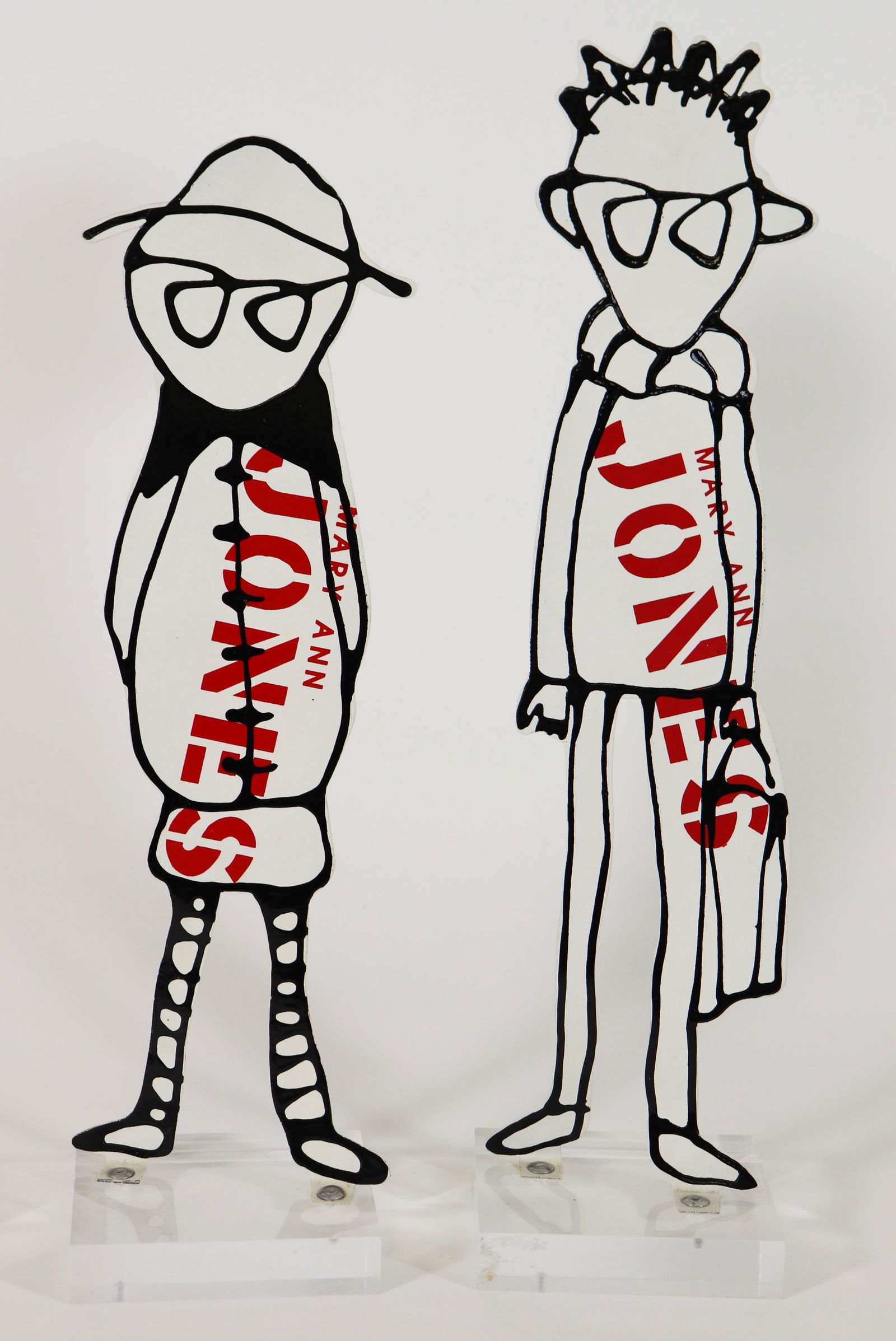 (2) MARY ANN JONES MIXED MEDIA SCULPTURES: Mary Ann Jones (American 20th century), Pair of mixed media Pop Art sculptures of cut metal with black outlines and colorful paint on back, on square lucite bases. Measures 15" and 13" tall by 3 " x 3