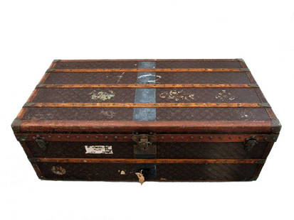 LOUIS VUITTON TRUNK: Early 20th century Louis Vuitton trunk. Trunk has original label inside with # 799159. Outside has wear as seen in pictures. One handle is loose but included, other handle is missing. Trunk measures 4