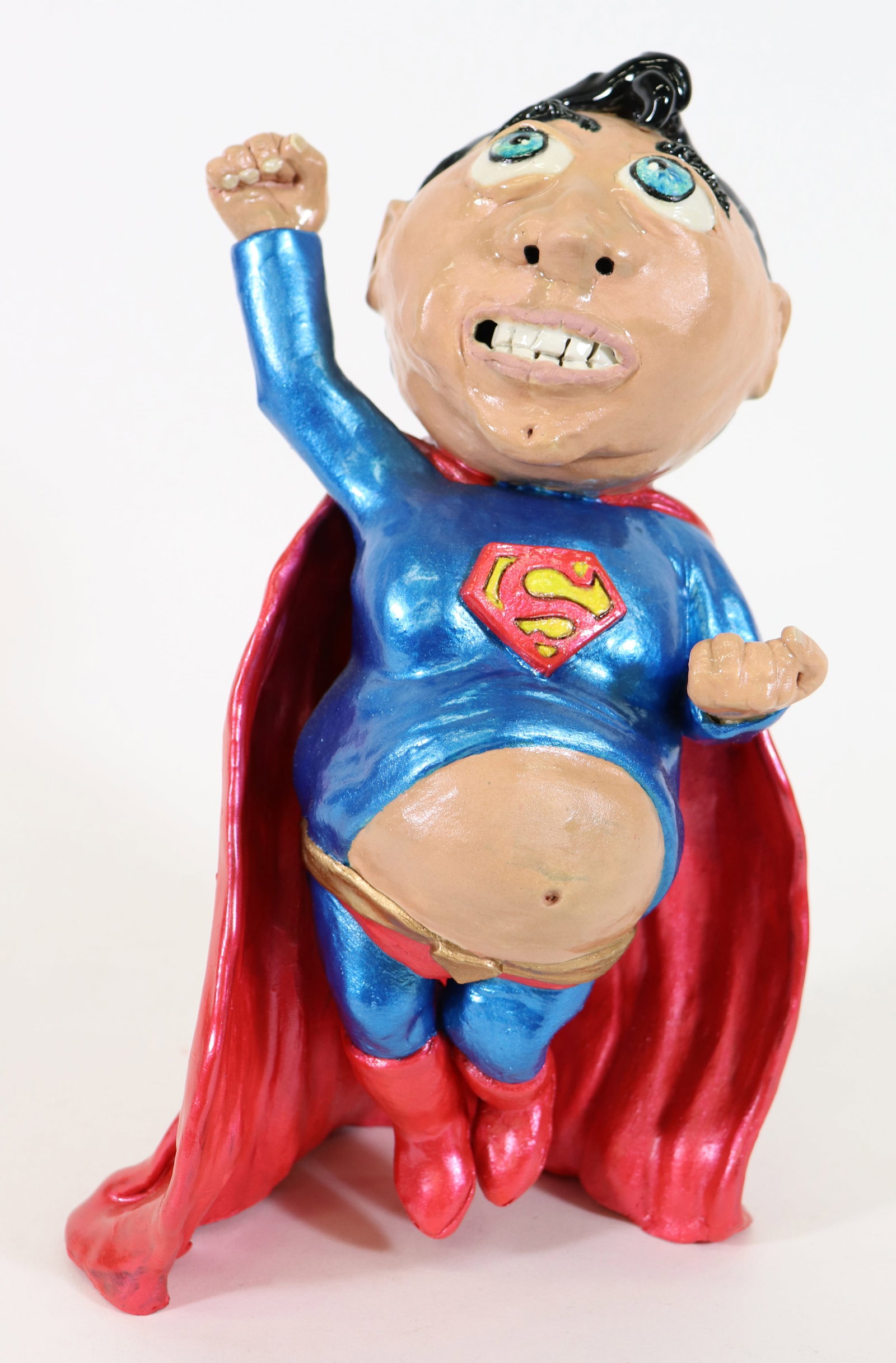 JEREMY WARDELL FOLK ART SUPERMAN SCULPTURE: Jeremy Wardell Folk Art pottery sculpture of a whimsical Superman super hero that had too much to eat! Measures 12" tall, 7' x 5.5" wide.