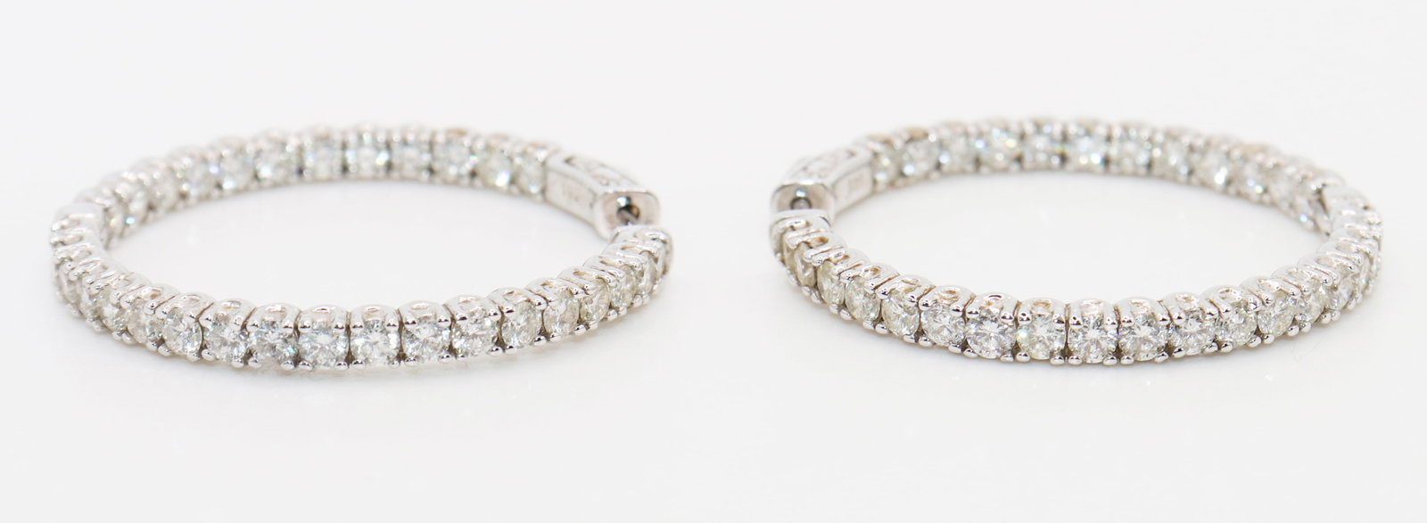 14K 5.10 CTW IN AND OUT DIAMOND EARRINGS w/CERT: A pair of 14K white gold diamond hoop earrings. They have diamonds on the inside and outside edge. There are a total of 62 diamonds totaling 5.10 carats. They are round brilliant diamonds, SI2-I1, H c