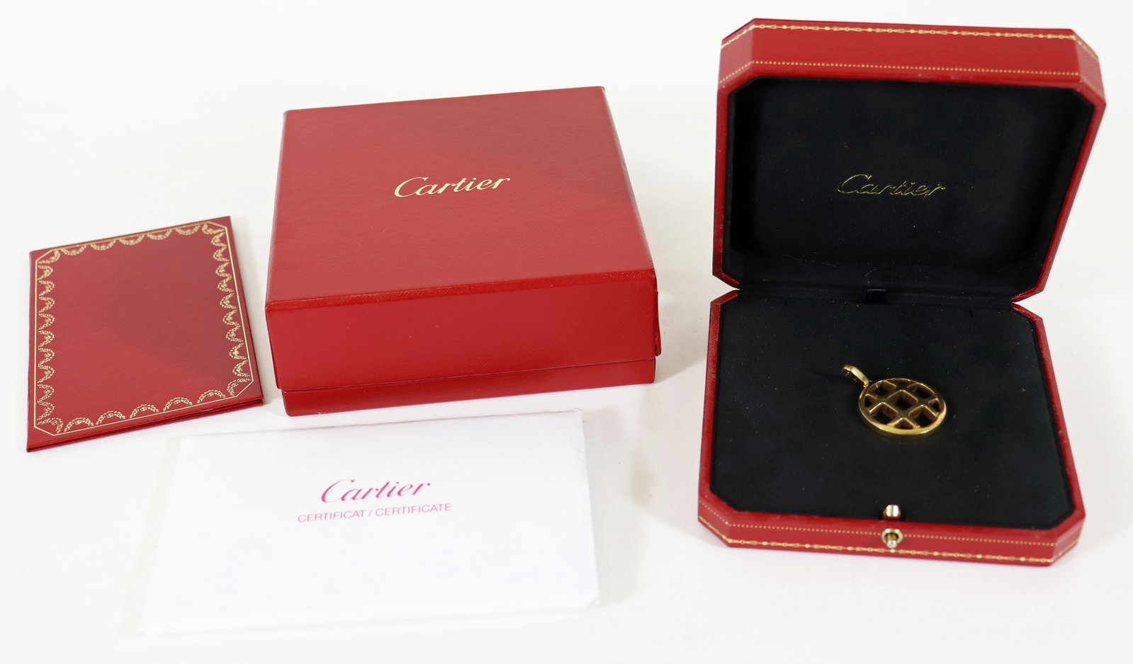 18K PASHA DE CARTIER GRILL CHARM PENDANT: An 18K yellow gold Cartier pendant. Approx 1 1/8" in diameter. Weight 20.2 g / 12.9 dwt. Marked 750 Cartier DY 6582. With Cartier box and papers.