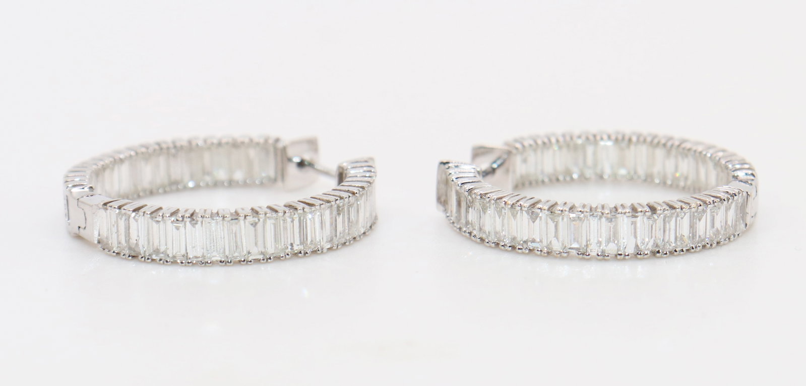 14K 3.53 CT. DIAMOND HOOP IN/OUT EARRINGS: A pair of 14K white gold hoop earrings with a total of 80 emerald cut diamonds totaling 3.53 carats. This diamonds are on the inside and outside of the hoop. They measure 1" wide and weigh 7.1 g/ 4.5 
