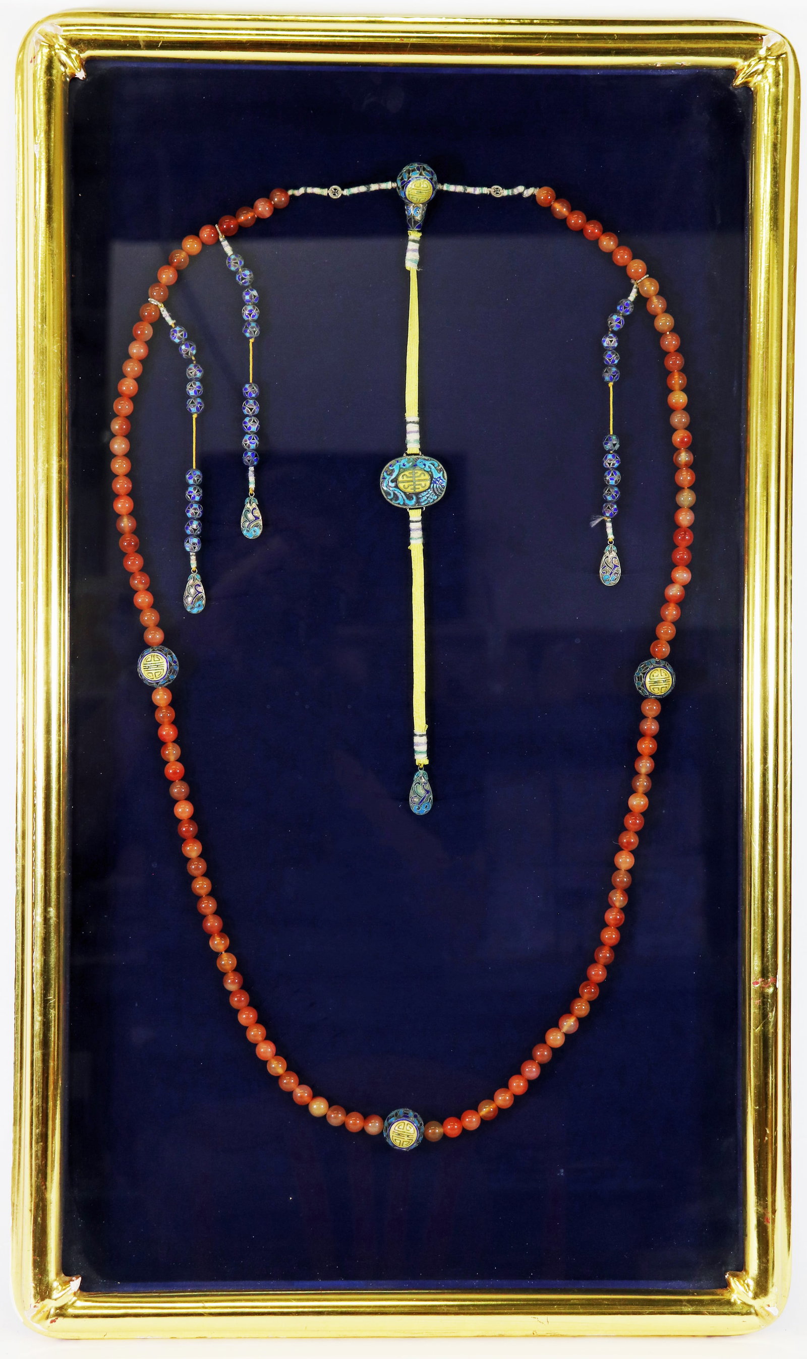 QING DYNASTY AMBER CHAO ZHU COURT NECKLACE: A Qing Dynasty Chaozhu court necklace with 108 amber beads with large fotou cloisonne / champleve beads and a Beiyun in the center . It is in a framed shadowbox (not examined from frame). The necklace