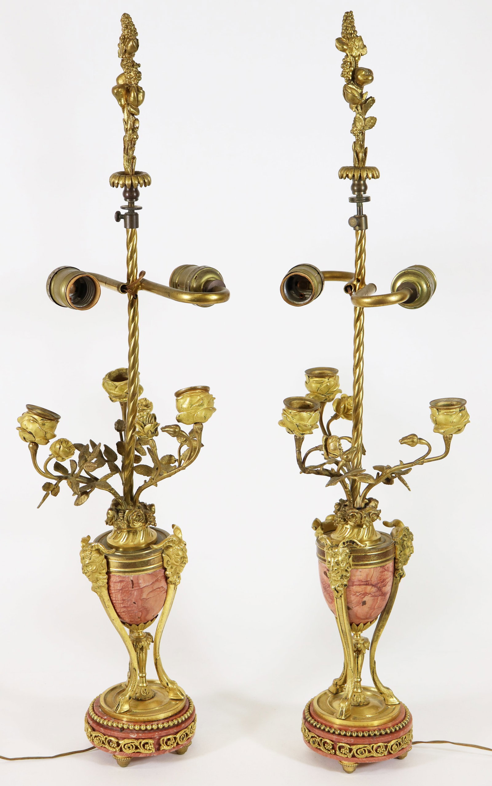 LOUIS XVI STYLE BRONZE & MARBLE CANDELABRA LAMPS: A pair of antique Louis XVI style gilt bronze mounted candelabra lamps. Marble urn formed body with 3 leaf form candle branches with 3 ram's heads and rosettes over a 3 footed base. 27" x 5.5" They ar