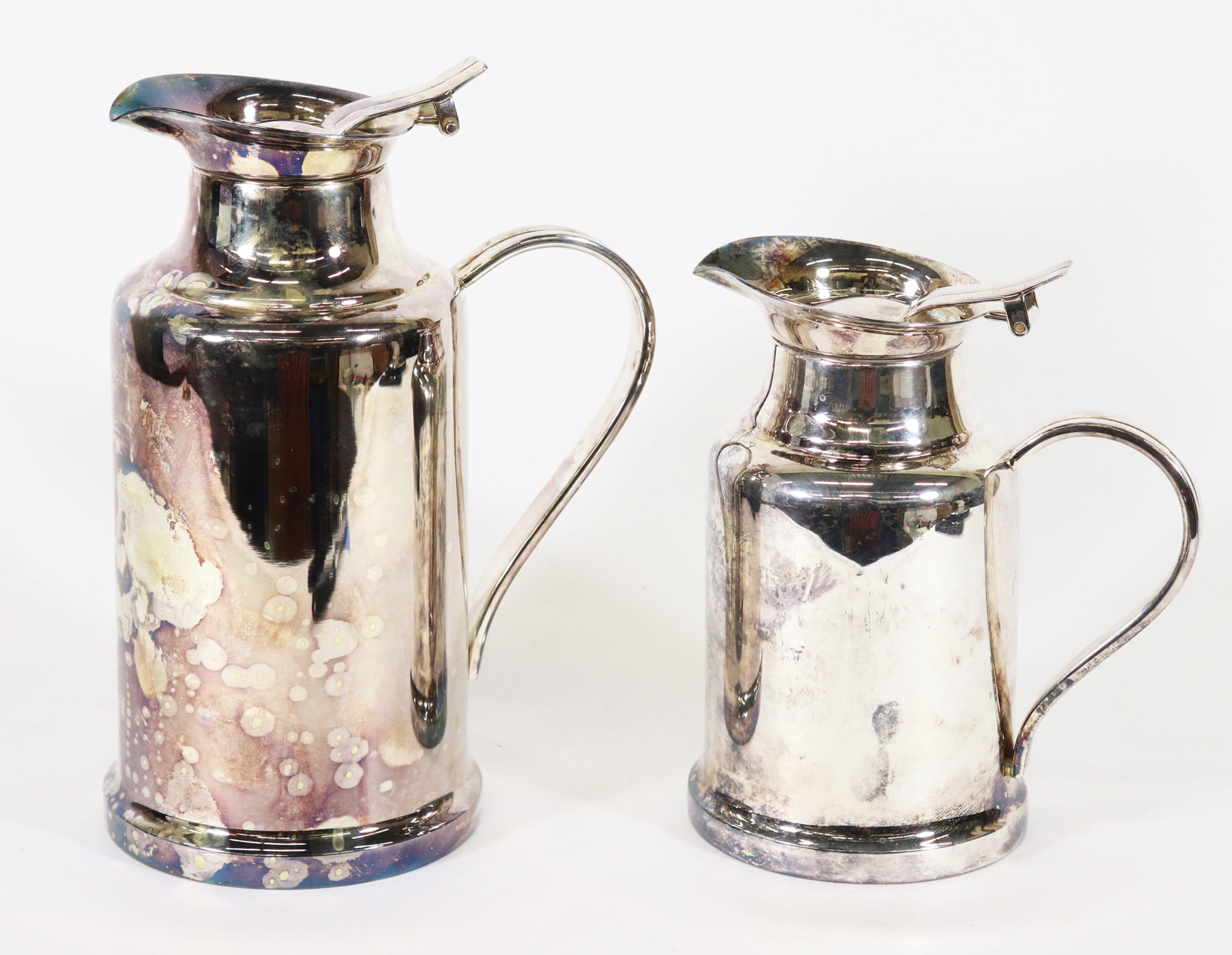 2 CHRISTOFLE FRANCE SILVERPLATE BAGATELLE THERMOS: A set of two Christofle silver plate insulated hot/cold thermos pitchers, marked Christofle. The large pitcher measures 9" x 7" x 4 1/2" and the smaller pitcher measures 7" x 5 1/2" x 4".