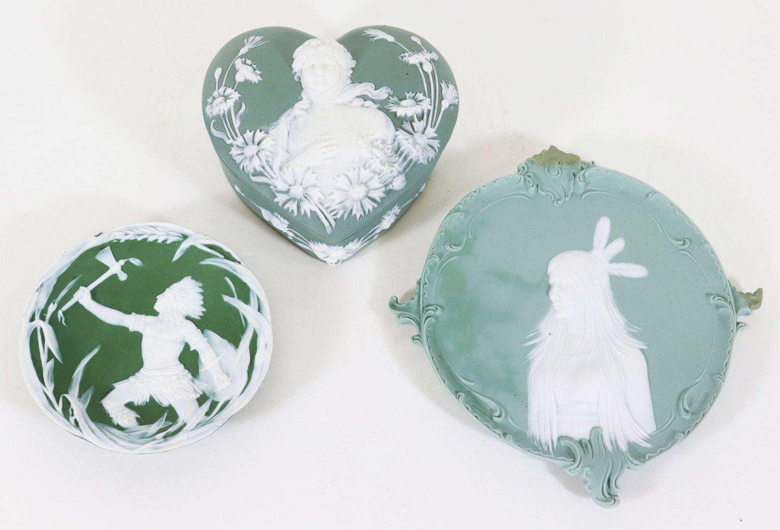 (3) GERMAN JASPERWARE RELIEF PORTRAIT PIECES: Three piece collection of German jasperware including a Schafer & Vater sage green portrait of a Native American Indian female motif in white, measures 7.5" x 6.5", a round Gebruder Heubach forest gre