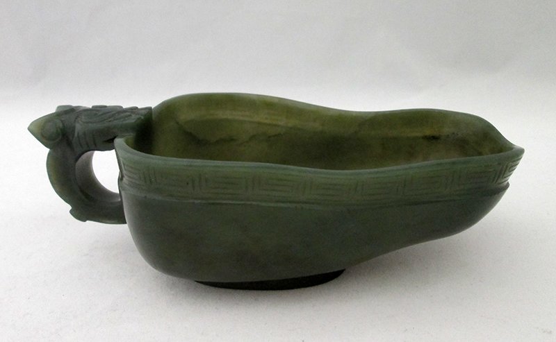 CHINESE GREEN JADE POURING CUP VESSEL: Spinach jade pouring cup vessel, or libation cup, with dragon handle. Measures 5 1/4" wide with handle and 1 3/4" tall at handle.
