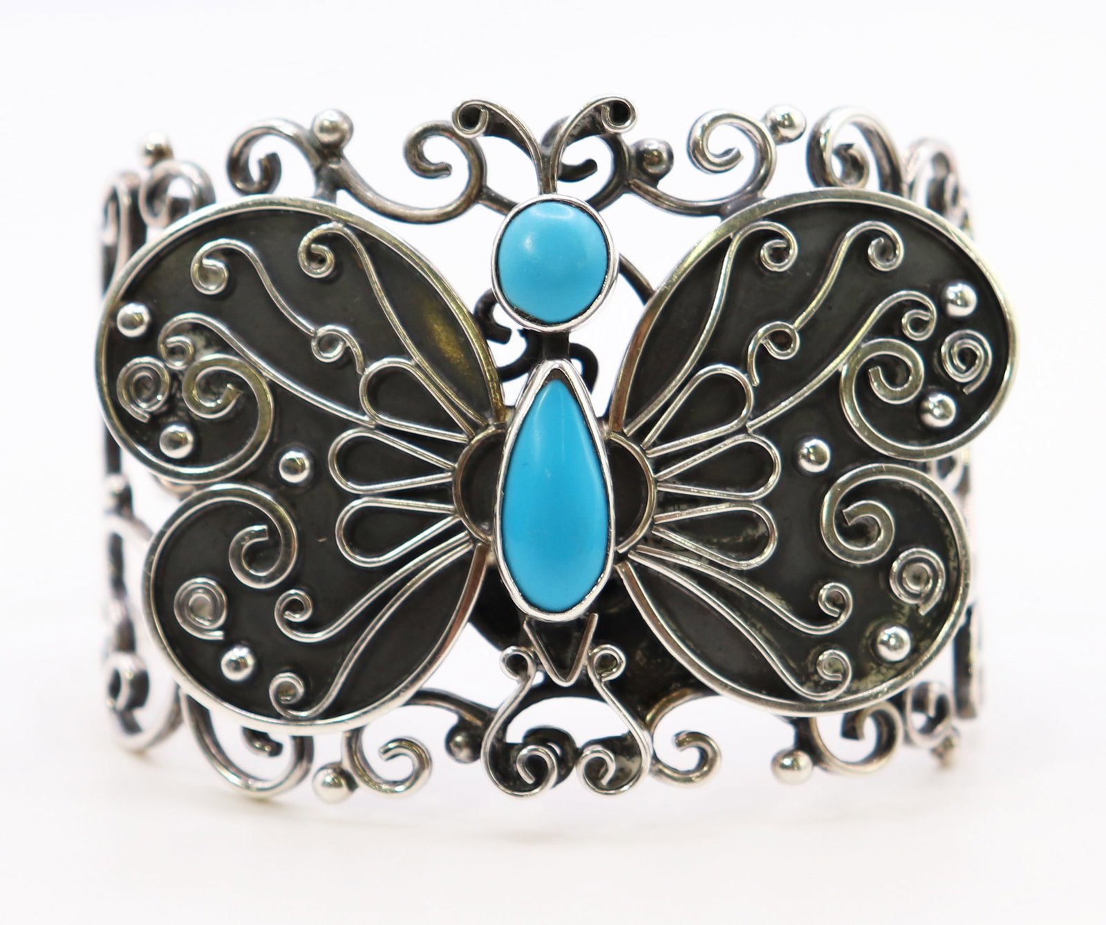 VINTAGE MEXICAN STERLING SILVER BUTTERFLY BRACELET: A sterling silver bracelet with a large butterfly with turquoise stones. Marked ATI Mexico 925. It measures 2" wide and has an open back. Weight 62g