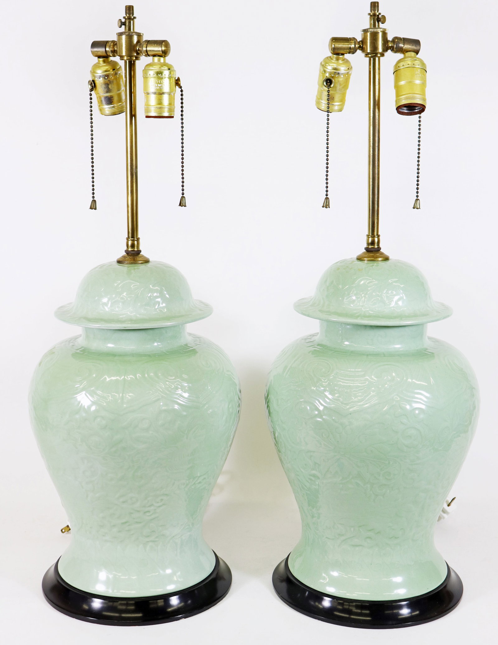PAIR OF CHINESE CELADON BALUSTER GINGER JAR LAMPS: Two Chinese celadon baluster lidded ginger jars with impressed design lamps. Each measures 26" tall, 9" wide.
