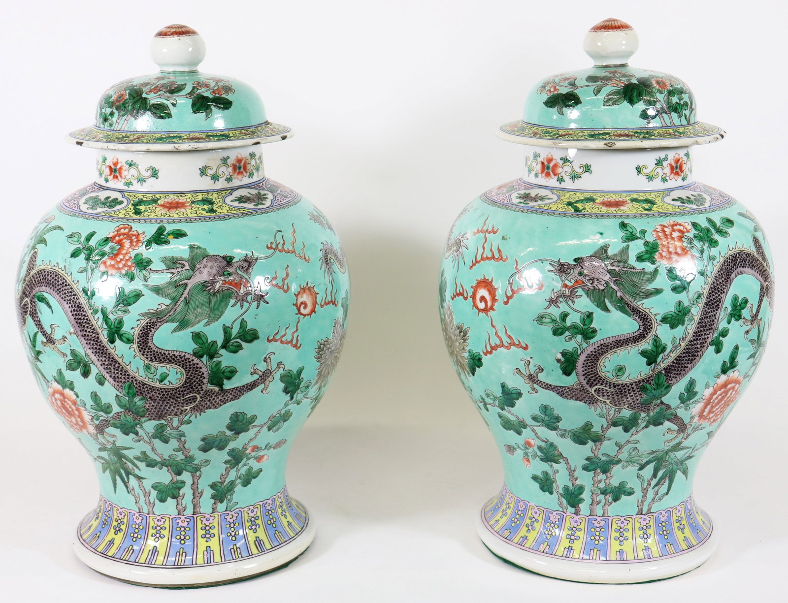 (2) CHINESE DRAGON LIDDED JARS: Pair of Chinese lidded vases with dragons and flowers. Blue four character mark on bottom. Some chips to edges of lids. Each measures approximately 18" tall, 11" wide.